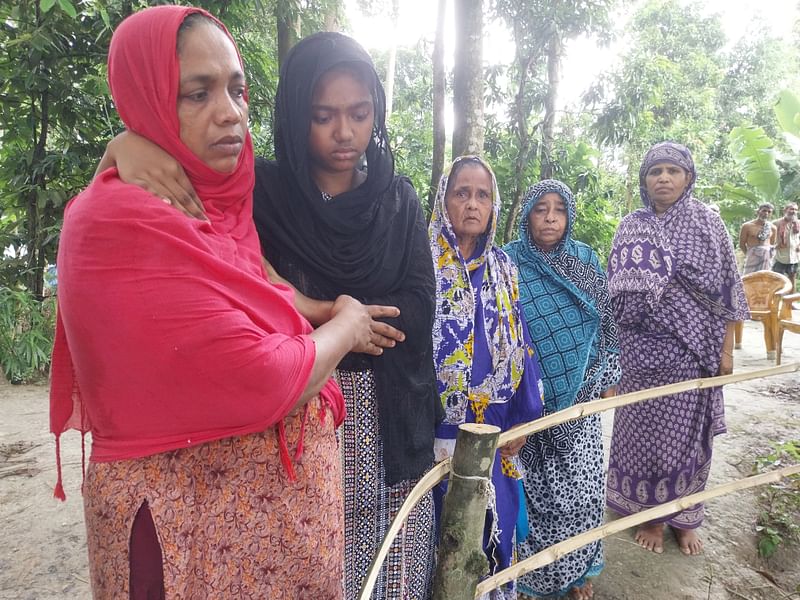 বাবার কবরের পাশে দাঁড়িয়ে মেয়ে নুজহাত হোসেন। পাশে নুজহাতের মা শিউলী আফরোজ। আজ সোমবার বরিশালের গৌরনদীতে